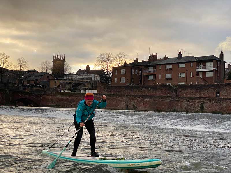 Man padlleboarding on the River Dee with Dee River Kayaking