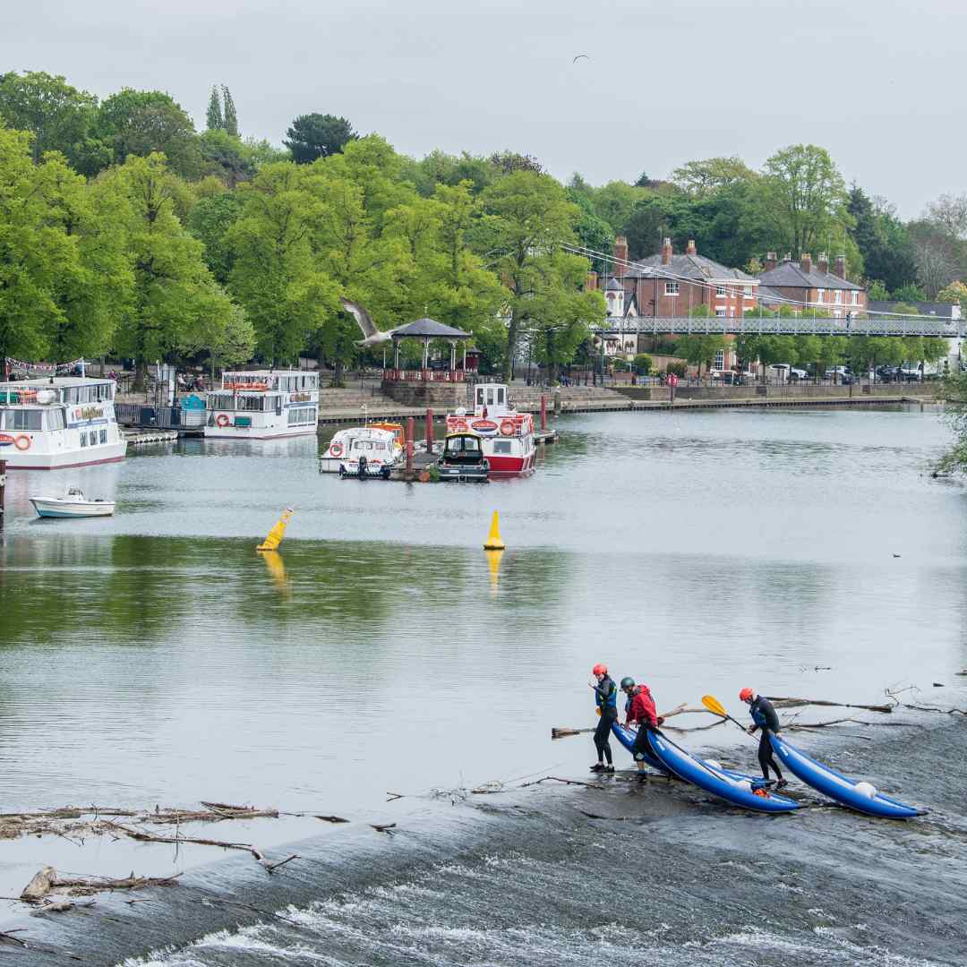 People with kayaks on the River Dee